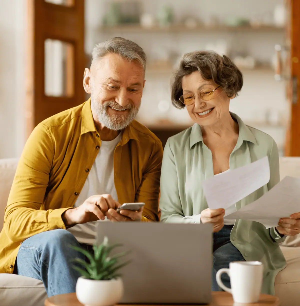 A couple sitting on a couch and looking at a computer