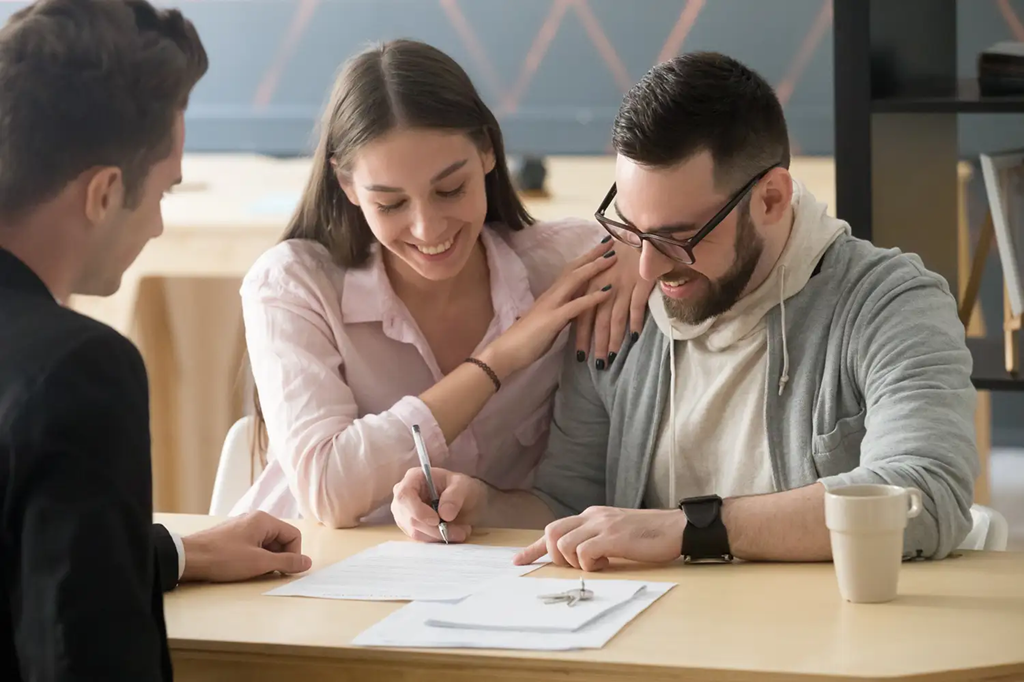 couple signing documents with agent