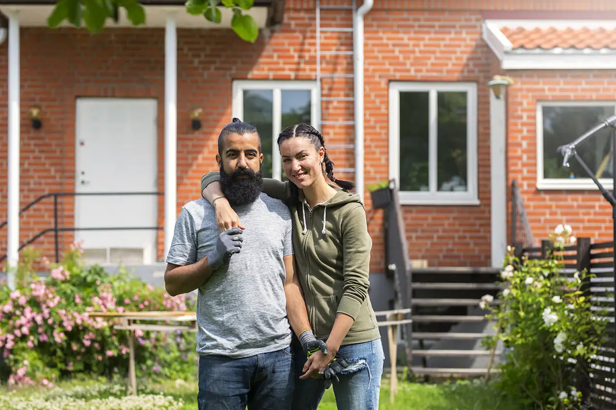 couple in garden in front of house