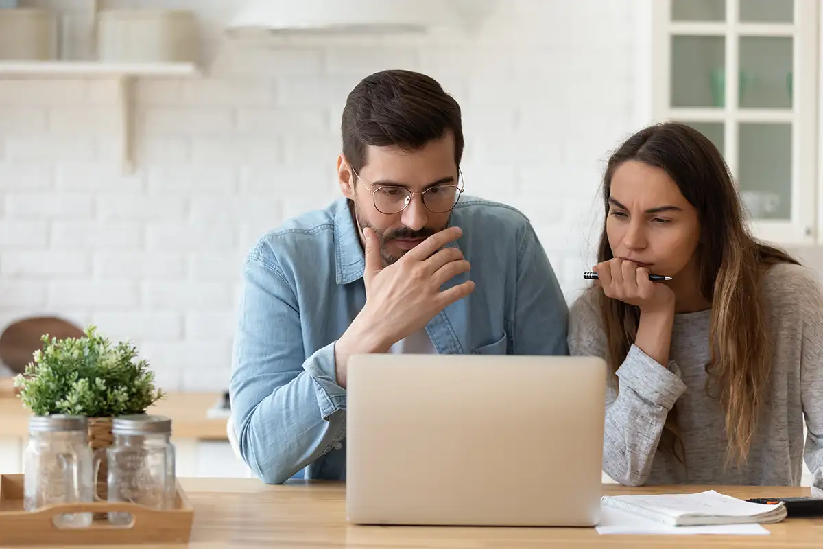 couple pondering at laptop