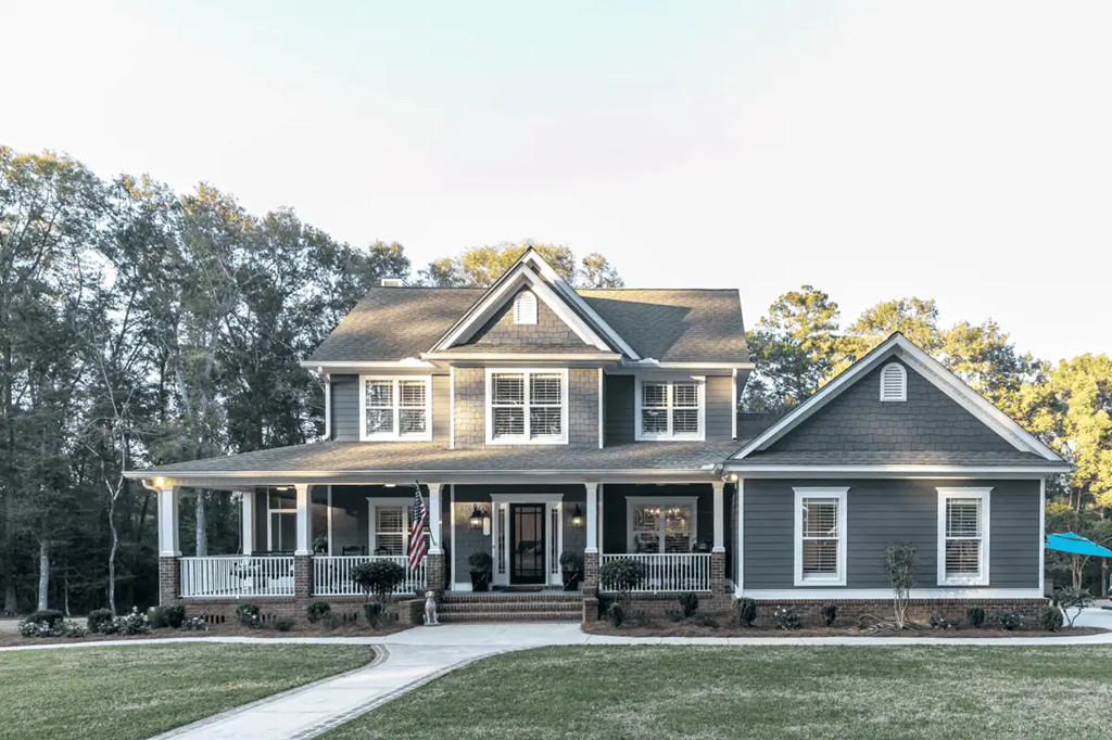 A two story home with grass yard