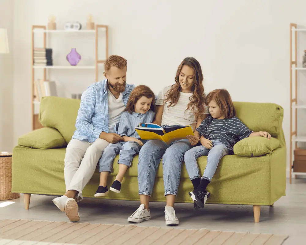 Family on a couch reading a book