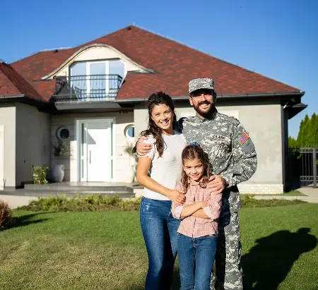 service member with family in front of home