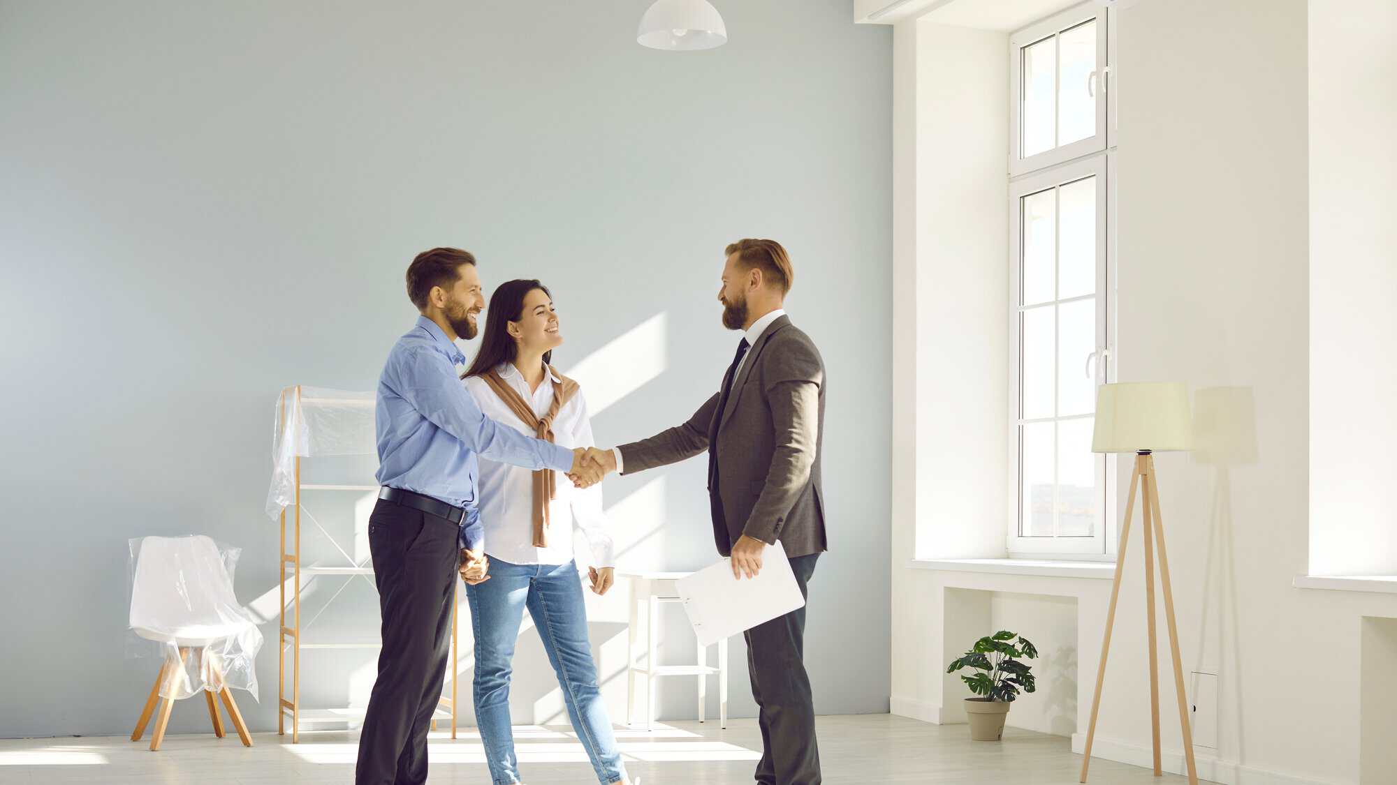 A couple shaking hands with realtor