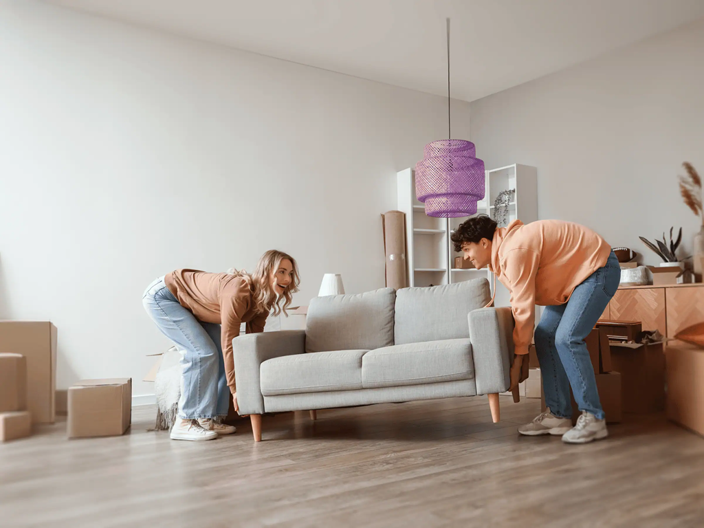 A young couple moving a couch