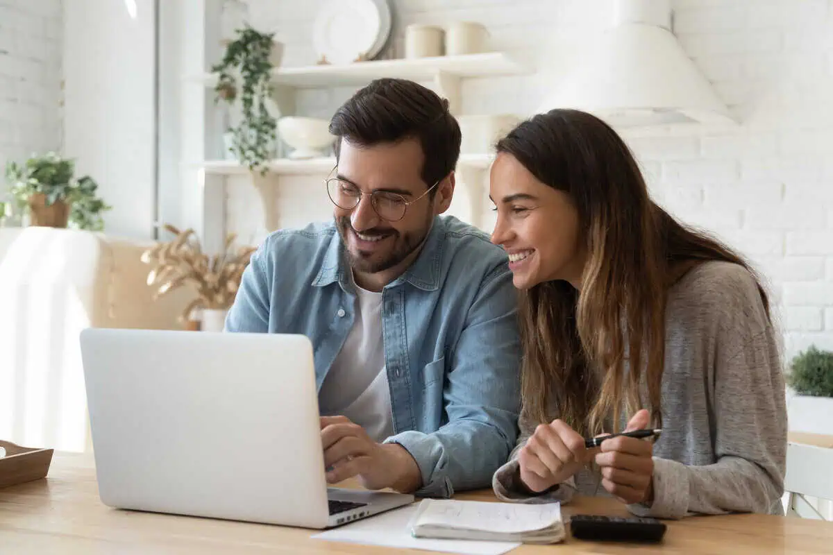 A couple looking at a computer and smiling