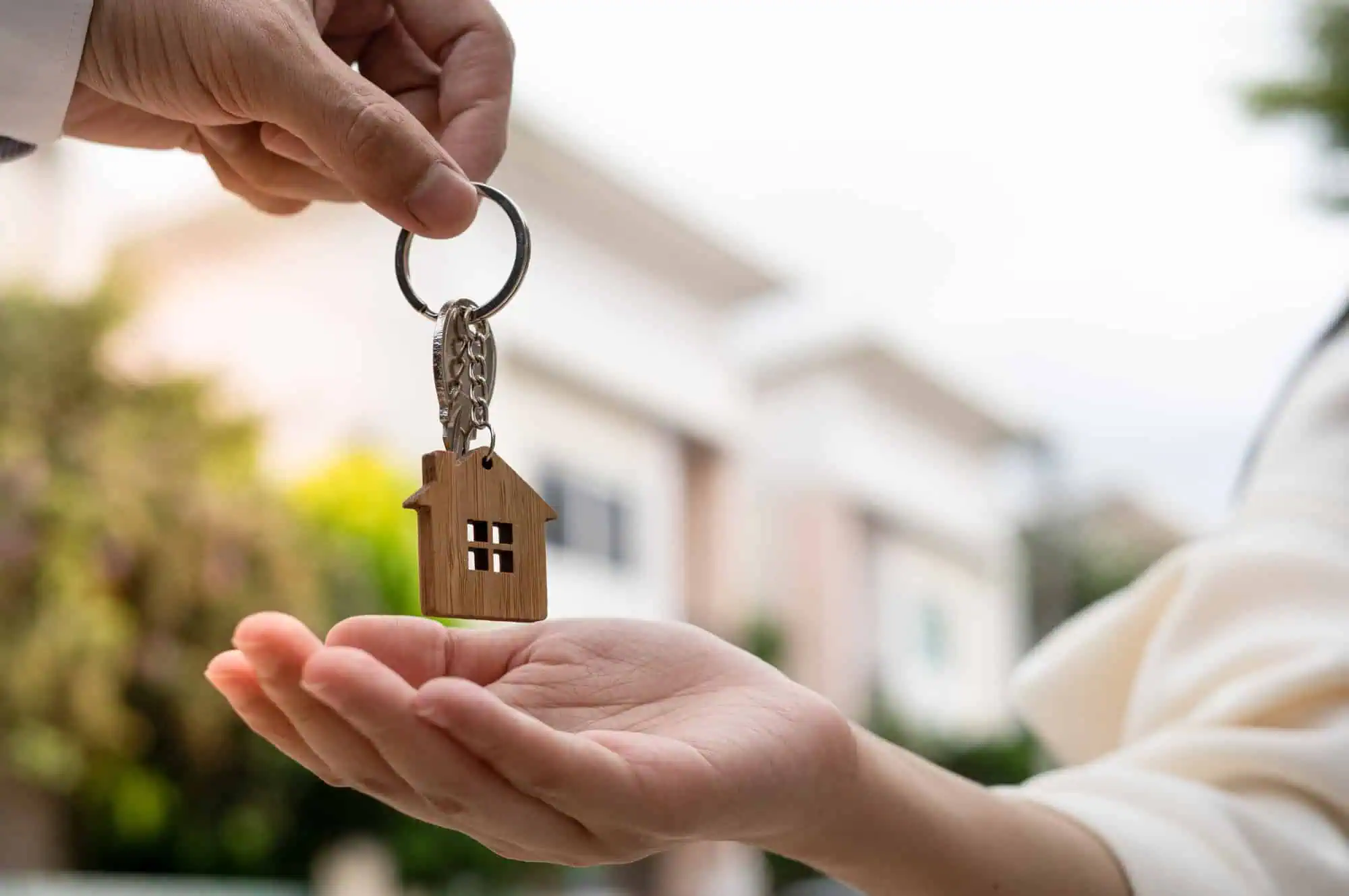 A person handing another a house key