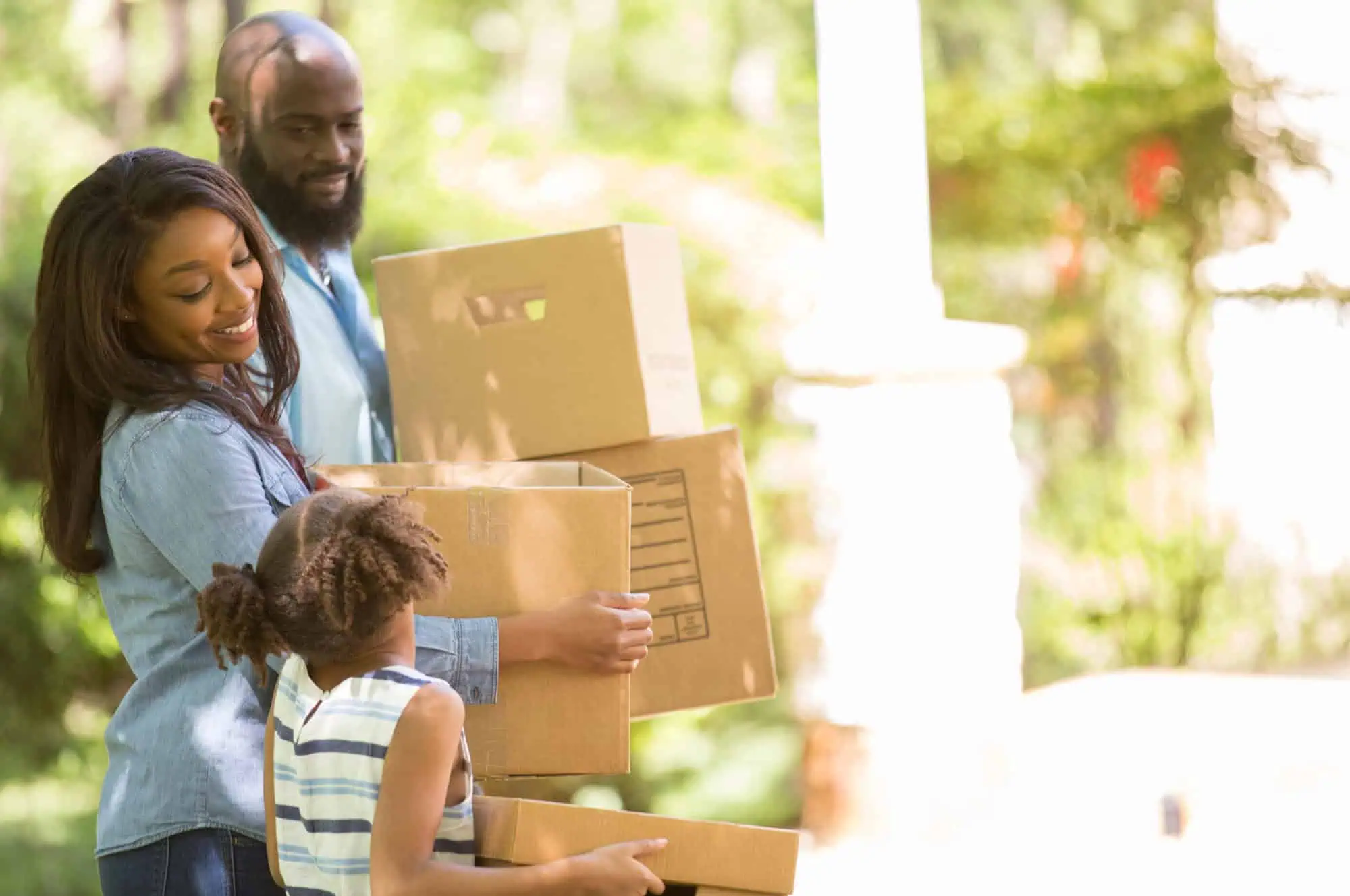 A family carrying moving boxes