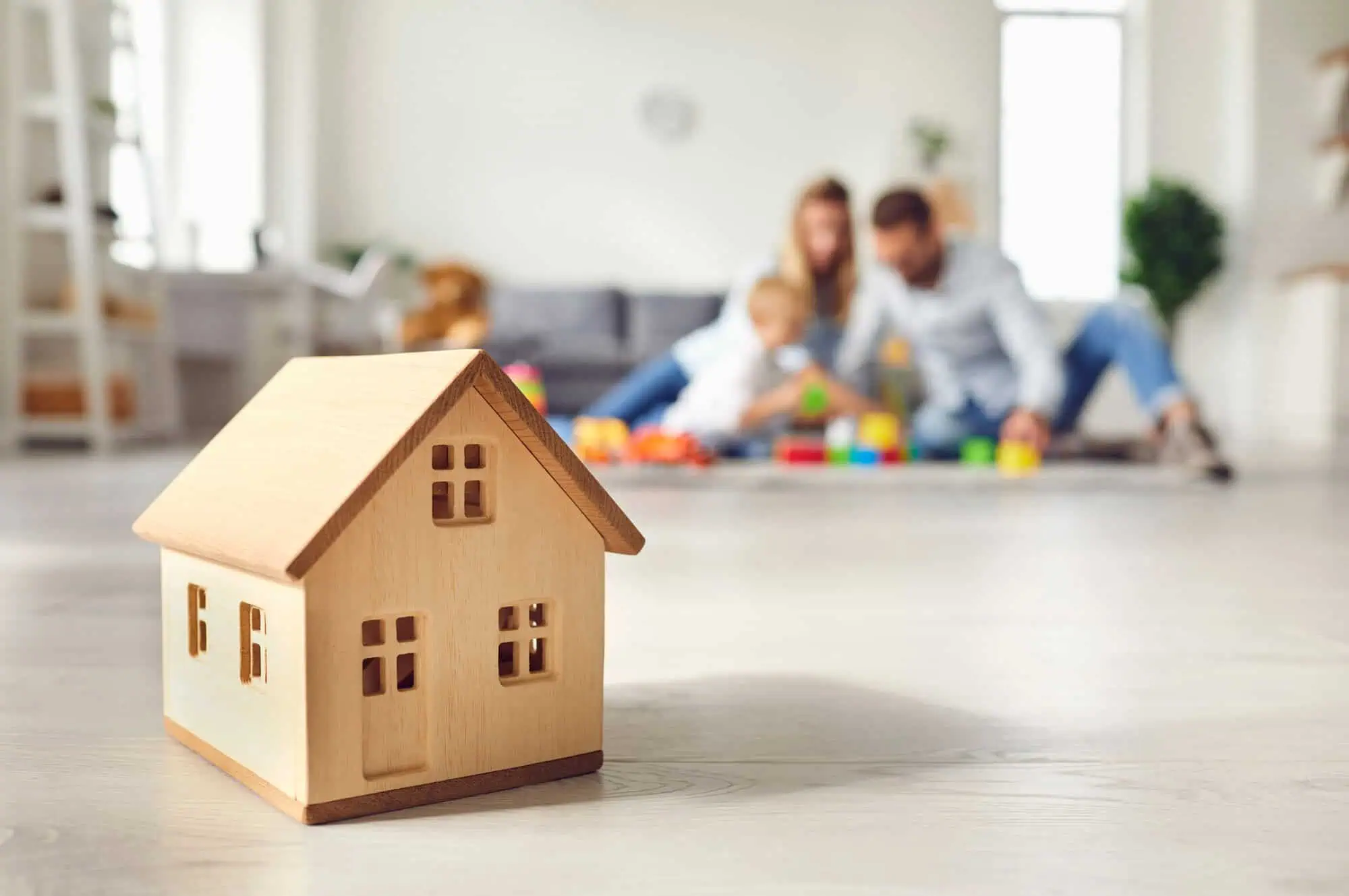 Family with young child sitting on floor and playing with toys