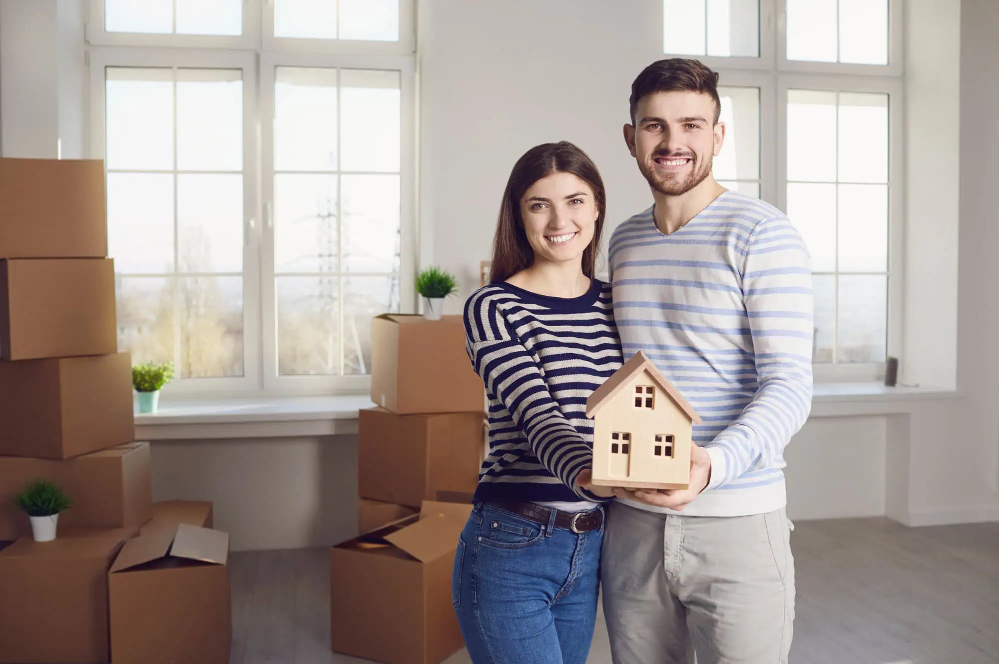 A couple holding a wood model house