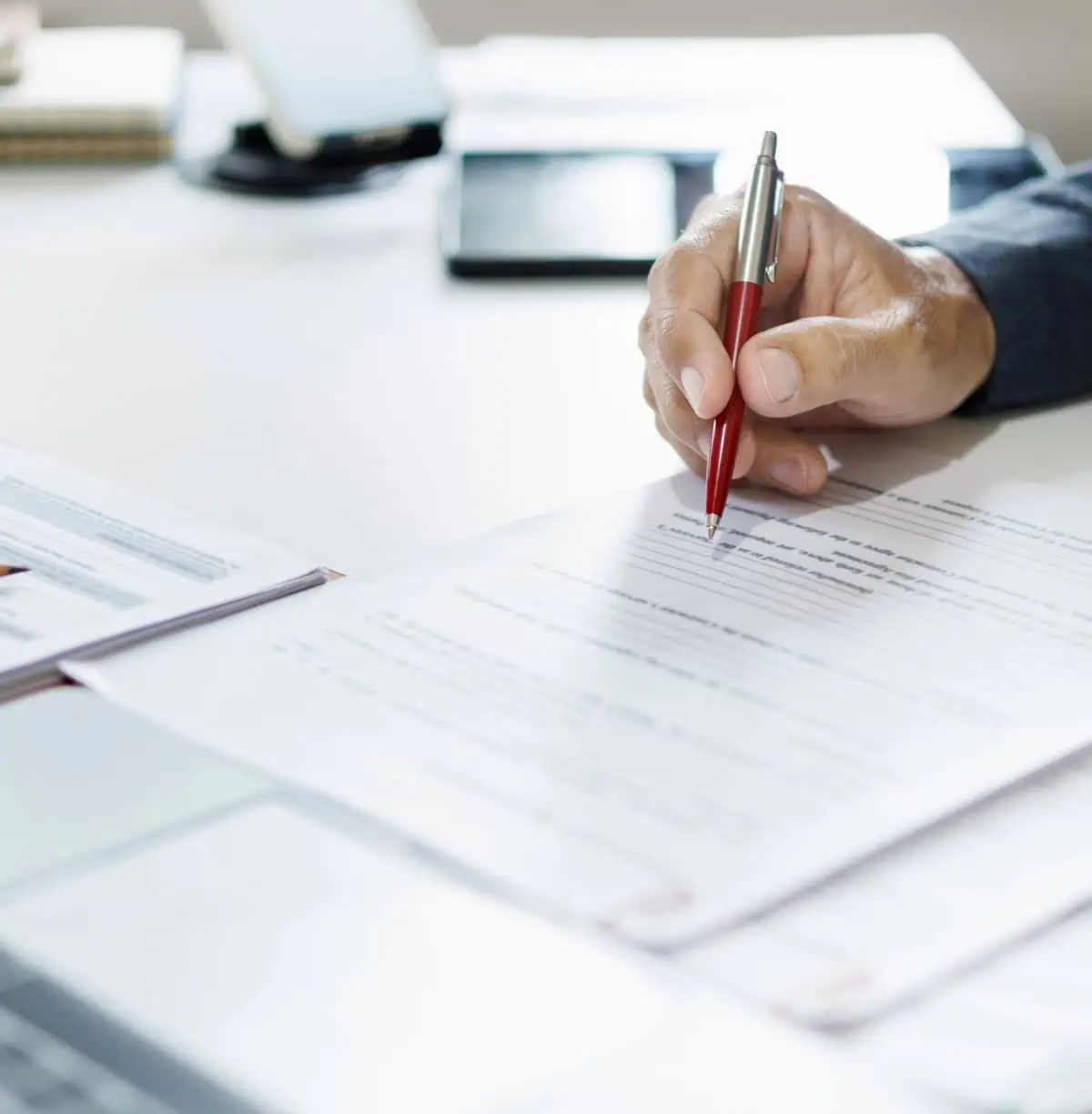 Person filling out paperwork with a pen