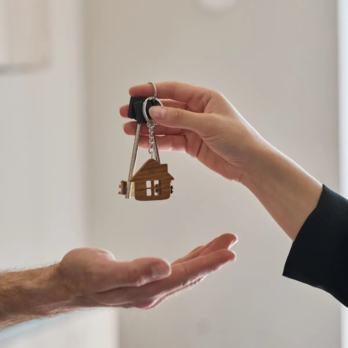 person handing keys to another person