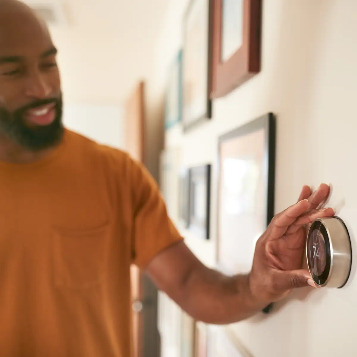 man adjusting thermostat