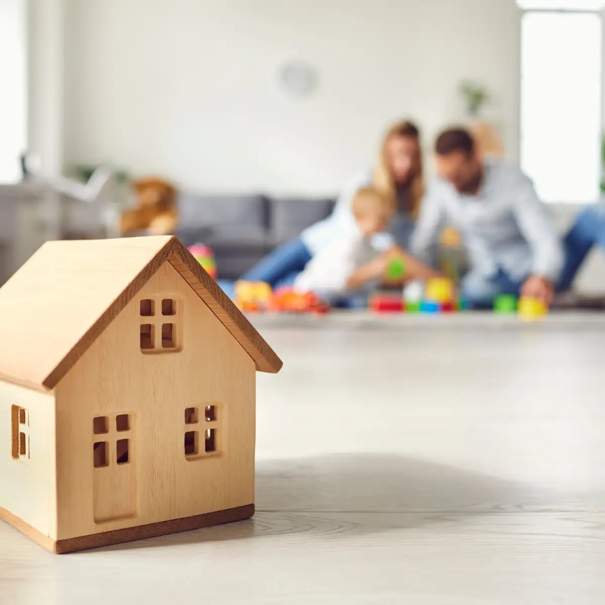 toy wood home with family in background